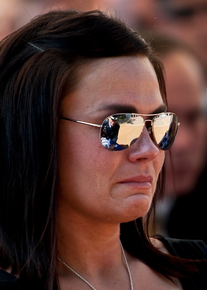 Kristen Johnson, widow of Senior Airman Daniel Johnson, tries to keep her composure after receiving a folded flag from Air Force Chief of Staff Gen. Norton Schwartz during the Explosive Ordnance Disposal Memorial ceremony May 7, 2011, at Eglin Air Force Base, Fla.  General Schwartz also presented a flag to Senior Airman Michael Buras’ widow, Emily, at the ceremony.  Fifteen new names were added to the memorial wall this year.  The total, which includes all services, now stands at 269.  (U.S. Air Force photo/Samuel King Jr.)