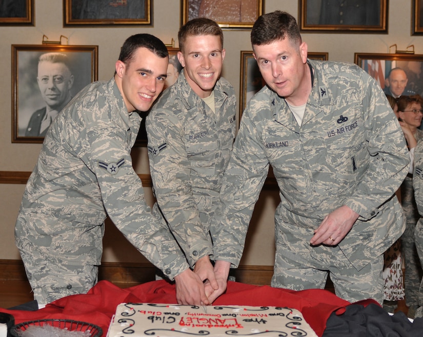 Airmen 1st Class Michael Leonard and Caleb Rupracht, 633d Communications Squadron core services technicians, assist Col. Donald Kirkland, 633d Air Base Wing commander, cut a cake during the grand opening of the Langley Club at Langley Air Force Base, Va., May 6, 2011. The Langley Club consolidates the enlisted and officers clubs' common heritage, and highlights shared success and professionalism.  (U.S. Air Force Photo/Tech. Sgt. April Wickes/released)