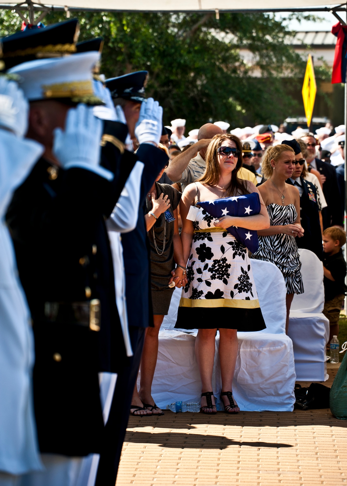 Emily Buras, widow of Senior Airman Michael Buras, reacts to the 21-gun salute during the Explosive Ordnance Disposal Memorial ceremony May 7 at Eglin Air Force Base, Fla.  Fifteen new names were added to the memorial wall this year.  The total, which includes all services, now stands at 269.  Airman Buras and Senior Airman Daniel Johnson were added to the Air Force wall. (U.S. Air Force photo/Samuel King Jr.)