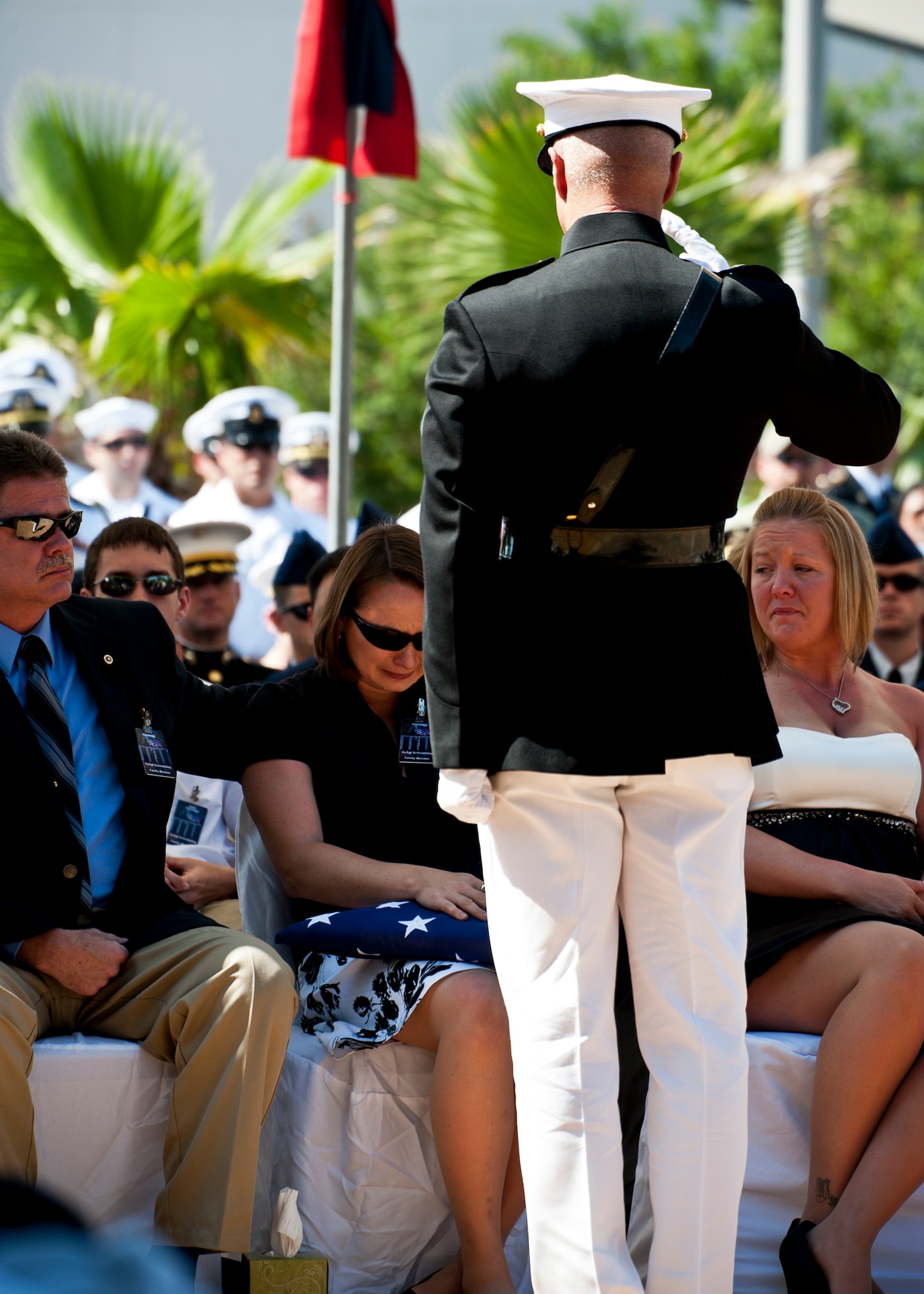 A Marine officer salutes the widow of a fallen explosive ordnance disposal technician after presenting an American Flag flown over the memorial during a ceremony May 7 at Eglin Air Force Base, Fla.  Fifteen new names were added to the memorial wall this year.  The total, which includes all services, now stands at 269.  The Marine Corps added eight names to the wall – Staff Sgts. Adam Perkins, Joshua Cullins, Jordan Emrick, Gunnery Sgt.s Christopher Eastman, Floyd Holley, Justin Schmalstieg, Master Sgt. Daniel Fedder and Sgt. Jason Smith. (U.S. Air Force photo/Samuel King Jr.)