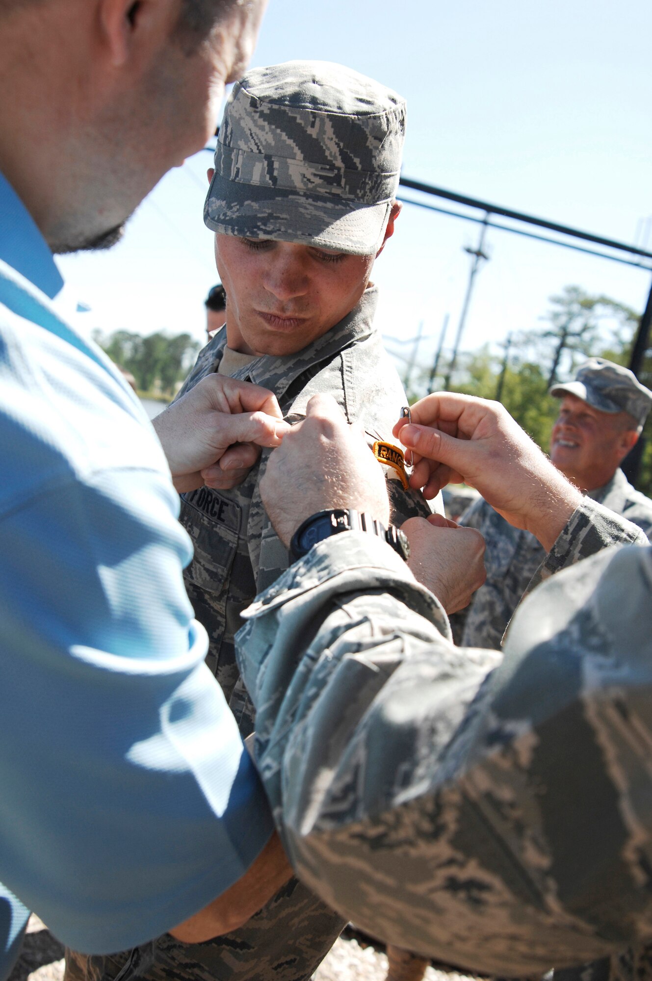 Airman 1st Class Matthew Garner has his Ranger tab pinned on by his father, Don Garner, and mentor, Staff Sgt. Seth Hunter, April 29, 2011. after completing the intense 61-day U.S. Army Ranger School at Ft. Benning, Ga. Airman Garner was the only Airman to make it through the course for this class and is one of fewer than 300 to make it since the school opened in the 1950s. Airman Garner is assigned to the 823rd Base Defense Squadron. (U.S. Air Force photo/Airman 1st Class Brigitte N. Brantley-Sisk)

