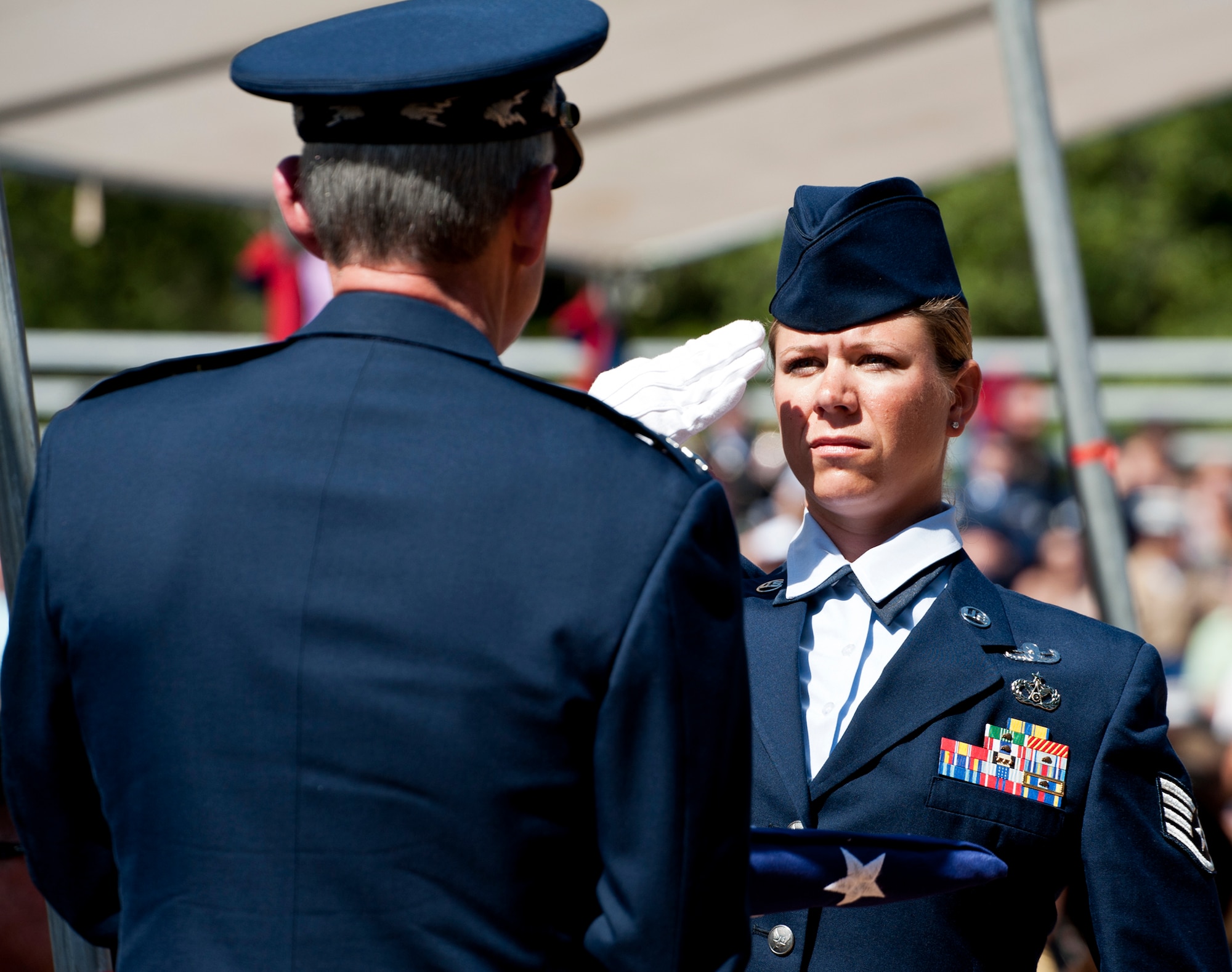 Staff Sgt. Lindsay Ahonen, 366th Training Squadron Det. 3, salutes Air Force Chief of Staff Gen. Norton Schwartz after passing him a flag during the Explosive Ordnance Disposal Memorial ceremony May 7, 2011, at Eglin Air Force Base, Fla.  General Schwartz presented flags to the widows of two fallen EOD Airmen from last year during the ceremony -- Senior Airmen Michael Buras and Daniel Johnson.  Fifteen new names were added to the memorial wall this year.  The total, which includes all services, now stands at 269. (U.S. Air Force photo/Samuel King Jr.)
