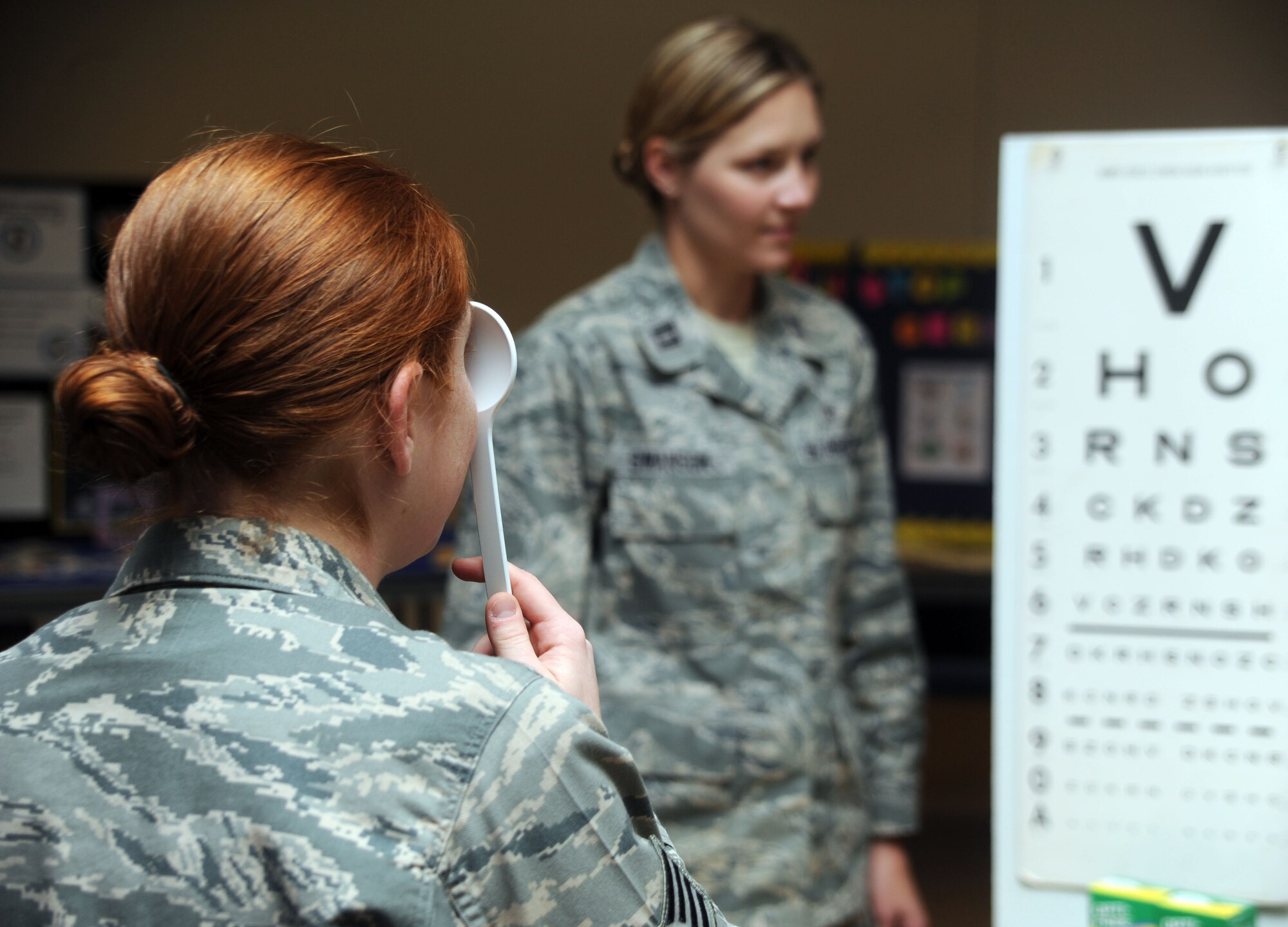ALTUS AIR FORCE BASE, Okla. – Staff Sgt. Amanda Bower, 97th Air Mobility Wing Safety technician, examines her eyesight using a visual acuity eye chart during the 2nd annual Wellness Exposition at the Freedom Community Center May 6. The exposition displayed more than 20 booths to inform base members about health and wellness.  (U.S. Air Force photo by Airman 1st Class Myles Stepp / 97th Air Mobility Wing Public Affairs)