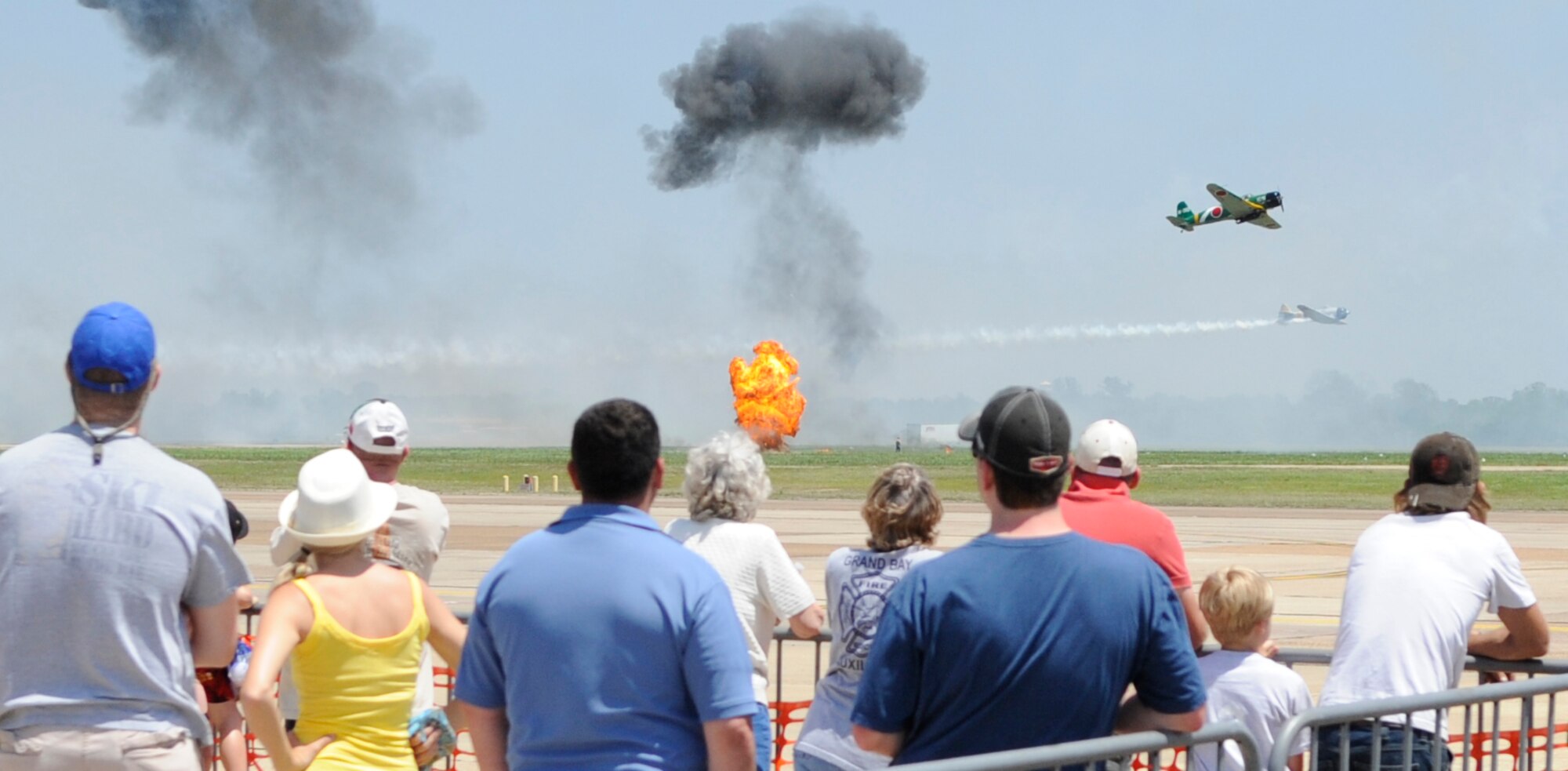 Spectators enjoy "Tora! Tora! Tora!" during the Defenders of Liberty Air Show at Barksdale Air Force Base, La., May 7. Tora! Tora! Tora! showed the crowd a depiction of the attack on Pearl Harbor. American and Japanese painted planes were performing simulated "dog fighting" along with explosions and pyrotechnics. (U.S. Air Force photo/Staff Sgt. John Gordinier)