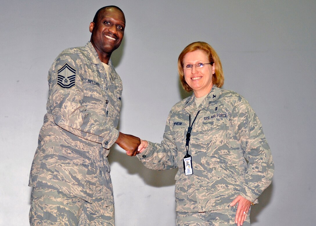 Colonel Nancy Opheim, Team Inspection Leader for the Air Force Inspection Agency, coins Senior Master Sgt. Tommy Belcher, 779th Medical Operations Squadron flight superintendent, during the Health Services Inspection outbrief Friday, May 6. Senior Master Sgt. Belcher received the coin for the outstanding job he did as the HSI team reception project officer. (U.S. Air Force photo/Senior Airman Laura Turner)