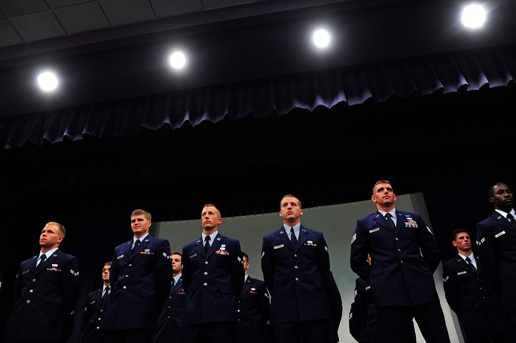Airmen from the 342nd Training Squadron Detachment 3 class Falcon 86 stand on stage before donning their black berets during a graduation ceremony, Hurlburt Field, Fla., May 3, 2011. During the 84 days of training, the Tactical Air Control Party students learned a wide range of skills including portable radio communications, combat field skills, day and night land navigation and many others skills that will be put to use and tested during their careers. (U.S. Air Force photo by Staff Sgt Julianne M. Showalter/Released)