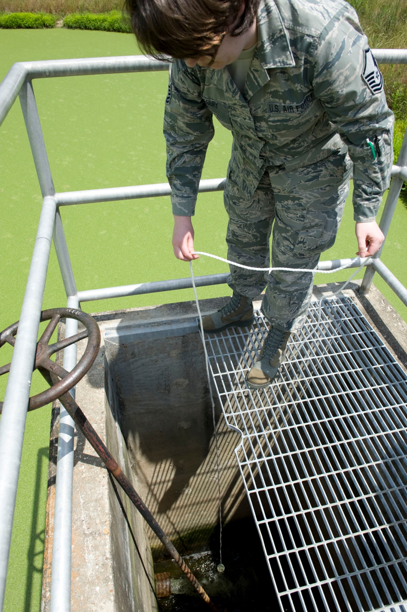 HAYNEVILLE, Ala. - Master Sgt. Tiffany Gregory, a public health technician with the 176th Medical Group, Alaska Air National Guard, collects a sample of water from the City of Hayneville?s waste-water treatment lagoon, May 8, 2011.  Gregory was in Alabama to help test the waste water for permit compliance and related treatment adjustments, and with drinking water for chlorine amount. She was also deploy with another seventy servicemembers from numerous military components and services in Hayneville for an Innovative Readiness Training (IRT) mission. The IRT program allows for real world training opportunities for military personnel while providing needed services to under-served communities in the United States. Alaska Air National Guard photo by Master Sgt. Shannon Oleson.