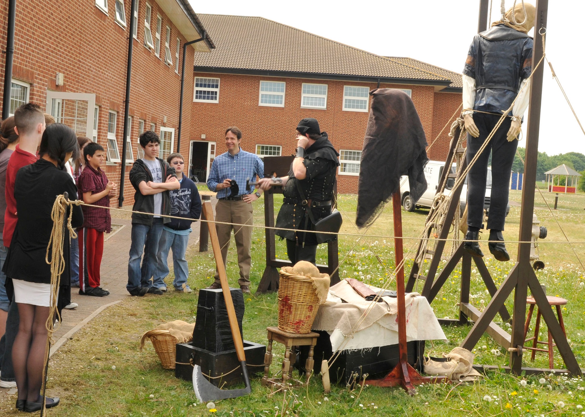 ROYAL AIR FORCE LAKENHEATH, England - John S. White, performance historian, consultant and technical advisor (center), explains how thieves in medieval times had their ears nailed to pillory frames to a group of Lakenheath Middle School 7th graders during U.K. day at LMS on May 6, 2011. U.K. Day provided the students the opportunity to learn about British history and culture through fun and educational activities. (U. S. Air Force photo/Senior Airman Tiffany M. Deuel)
 
