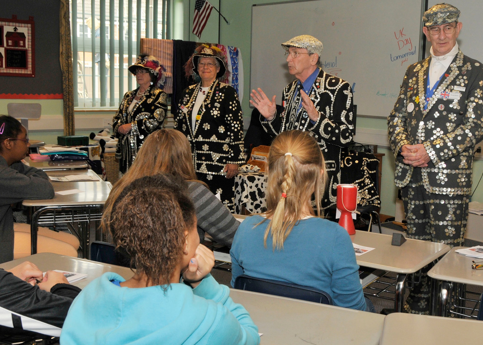 ROYAL AIR FORCE LAKENHEATH, England -The Pearly Kings and Queens visit students at Lakenheath Middle School during U.K. Day on May 6, 2011. The Pearly Kings and Queens, wearing suits donned with pearl buttons, educated the students on their history in England. U.K. Day provided the students the opportunity to learn about the history and culture of England through activities ranging from traditional dances to making scones.  Nearly 60 British performers participated in teaching the children about England through fun activities. (U.S. Air Force photo/Senior Airman Tiffany M. Deuel) 