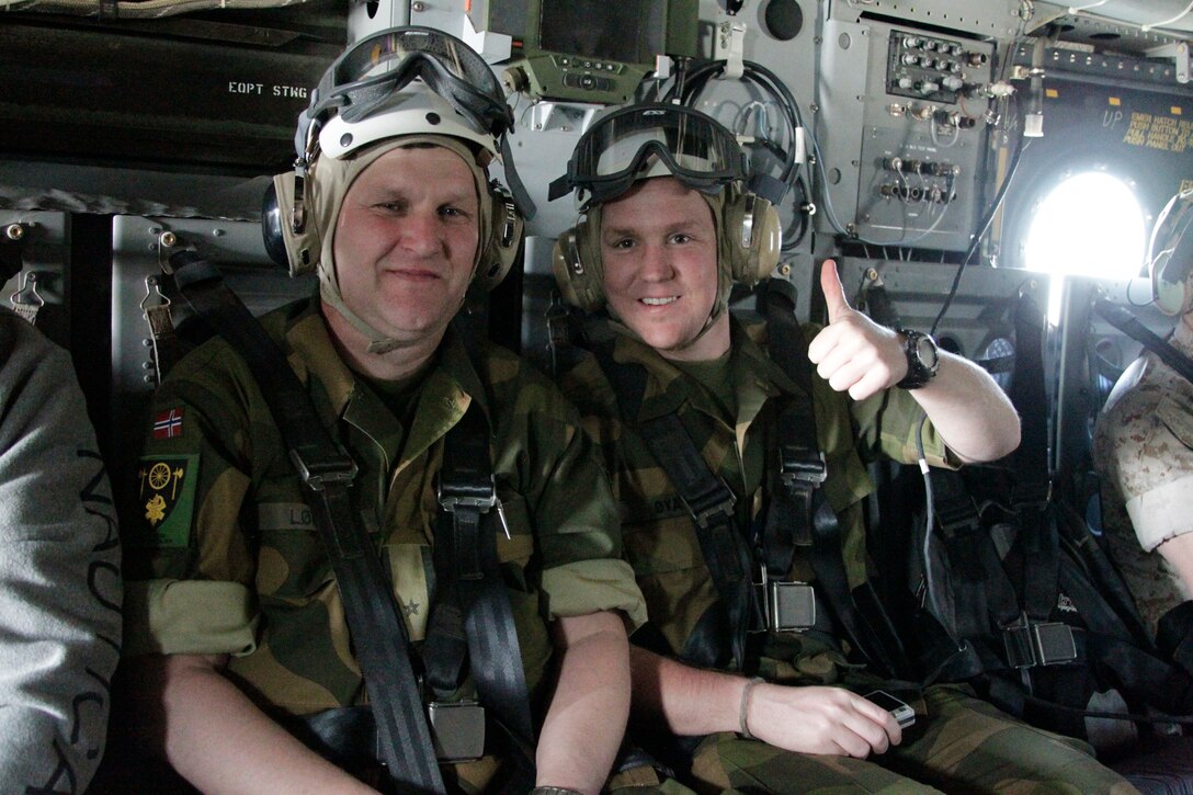 Major Hans Petter Loeken [left] and Capt. Kay Bjornar Oyas, both officers on the Norwegian defense staff, show their excitement before their first Osprey ride May 10, 2011. The visitors are departing from Miramar to the Mountain Warfare Training Center Bridgeport for their annual orientation tour.