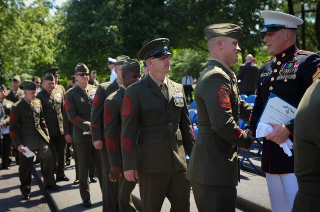 Gunnery Sgt. Thomas Hartrick, followed by fellow 1st Reconnaissance Battalion Marines, congratulates Gunnery Sgt. Brian M. Blonder after he received the Navy Cross during a ceremony at the Marine Corps War Memorial in Arlington, Va., May 10, 2011. Blonder, a reconnaissance Marine, received the second highest award given for valor in the face of danger for his actions during an all-day firefight against Taliban insurgents Aug. 8, 2008, during the battle of Shewan, Afghanistan. Although he and the Marines and sailors he was fighting alongside with were heavily outnumbered against insurgents, they managed to kill more than 50 insurgents and drove the rest out of their fortified fighting positions in the Taliban infested village in southern Farah province. Blonder was serving as platoon sergeant with a force reconnaissance platoon attached to 2nd Battalion, 7th Marine Regiment.