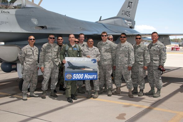 Col. Lenny Dick accepts a poster May 9 commemorating his 5,000th F-16 Fighting Falcon flying hour from aircraft maintainers assigned to the 162nd Fighter Wing. Known as “F” Flight, the team supports the Air National Guard Air Force Reserve Command Test Center with regular maintenance as well as unique test modifications. Since he arrived in Tucson in 2005, Colonel Dick has never experienced an in-flight emergency. (U.S. Air Force photo/Master Sgt. Dave Neve)