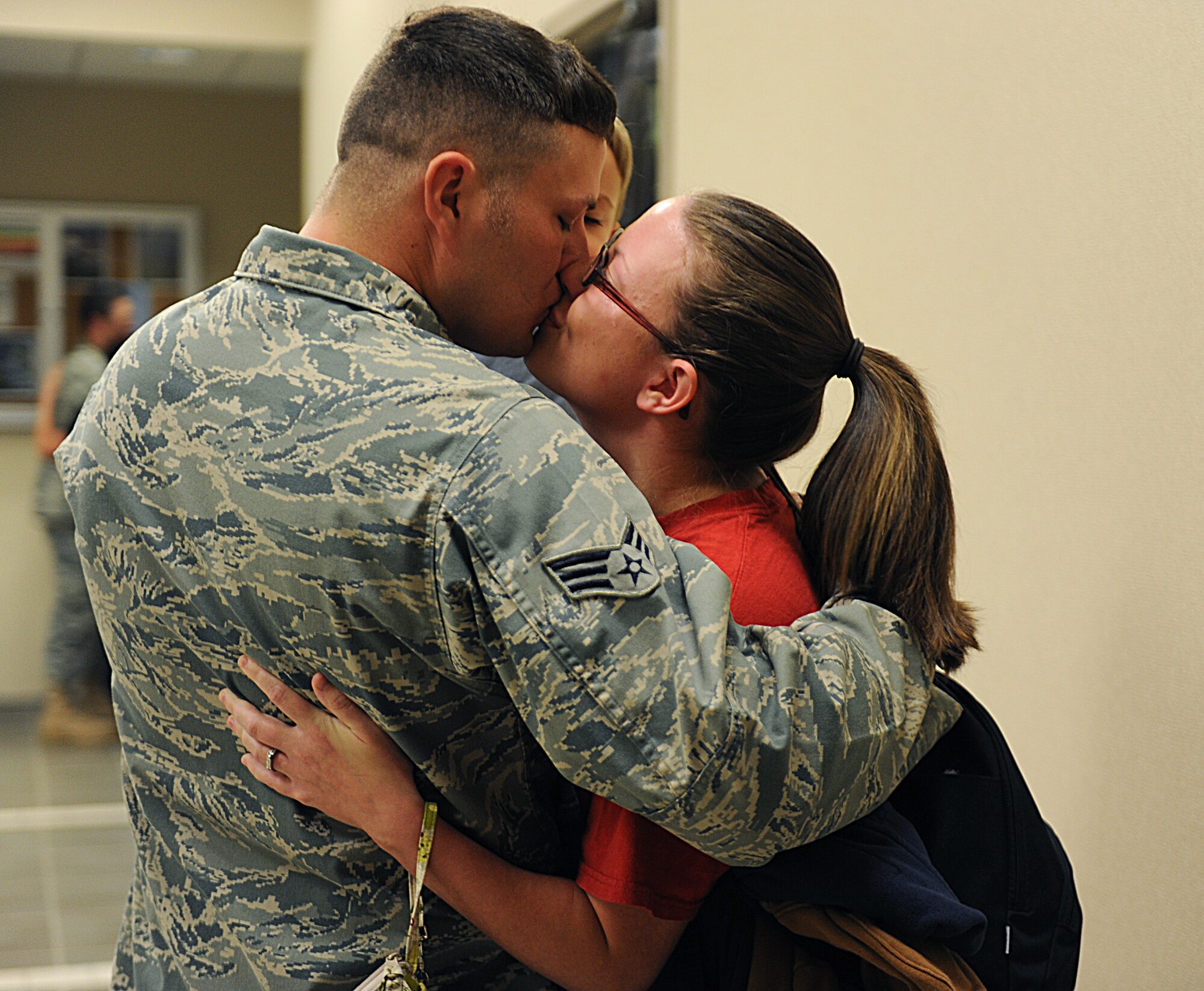 Senior Airman James Nunley, 19th Aircraft Maintenance Squadron electronic warfare journeyman, kisses his wife, Lindsey, as he prepares to depart to Southwest Asia May 7.  The group was the last of the deployment push that saw nearly 20 C-130 aircraft and 1,000 Airmen leave for their deployments in the wake of the April 25 tornado rated an EF-2 on the Enhanced Fujita Scale (111 to 135 mph) that struck the base. (U.S. Air Force photo by Airman 1st Class Ellora Stewart) 