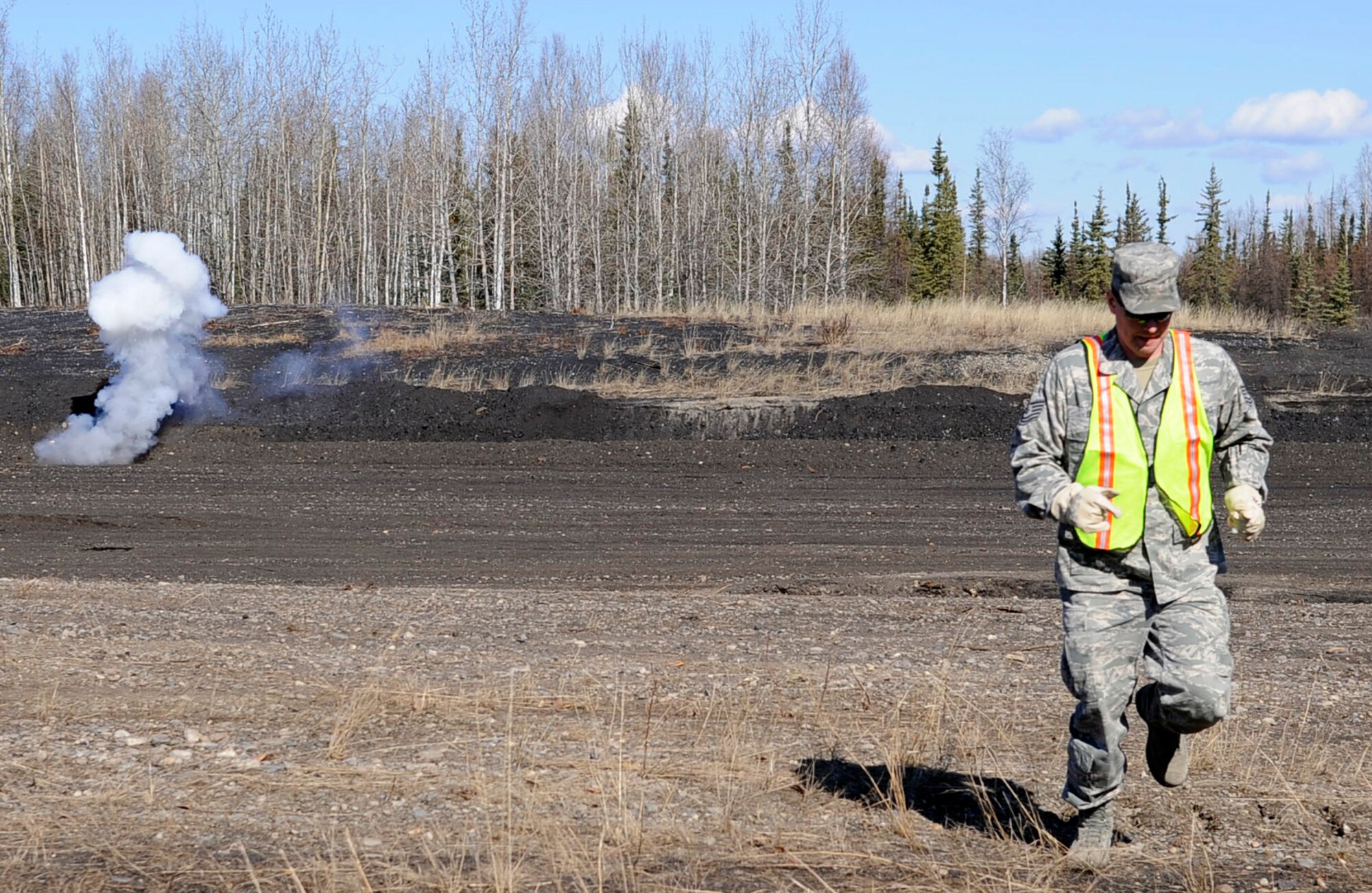 Tech. Sgt. Cliff Benson moves to a safe distance after throwing a ground burst simulator during an operational readiness exercise evaluation May 5, 2011, Eielson Air Force Base, Alaska. The evaluation tests Airmen's ability to survive and operate in a simulated chemical, biological, radiological, nuclear, and high yield explosive environment. Sergeant Benson is the non-commissioned officer in charge of the 354th Fighter Wing Exercise and Evaluations Flight. (U.S. Air Force photo/Airman 1st Class Laura Goodgame) 