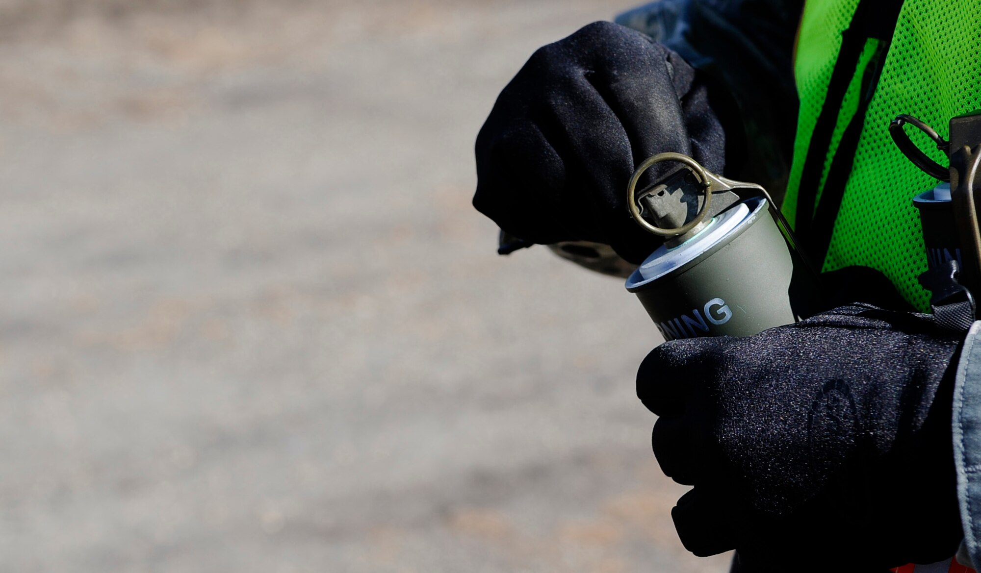 Staff Sgt. Jon Burnett pulls the pin from a smoke grenade during an operational readiness exercise evaluation May 5, 2011, Eielson Air Force Base, Alaska. The evaluation tests Airmen's ability to survive and operate in a simulated chemical, biological, radiological, nuclear, and high yield explosive environment. Sergeant Burnett is the non-commissioned officer in charge of emergency management, 354th Civil Engineer Squadron. (U.S. Air Force photo/Airman 1st Class Laura Goodgame)  