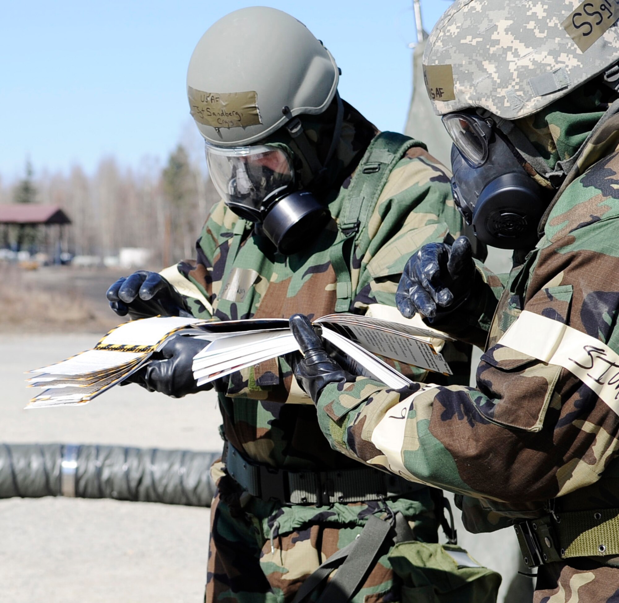 Airmen flip through their Airman's manual for instructions on how to identify a threat during an operational readiness exercise evaluation May 5, 2011, Eielson Air Force Base, Alaska. The evaluation tests Airmen's ability to survive and operate in a simulated chemical, biological, radiological, nuclear, and high yield explosive environment.  (U.S. Air Force photo/Airman 1st Class Laura Goodgame) 