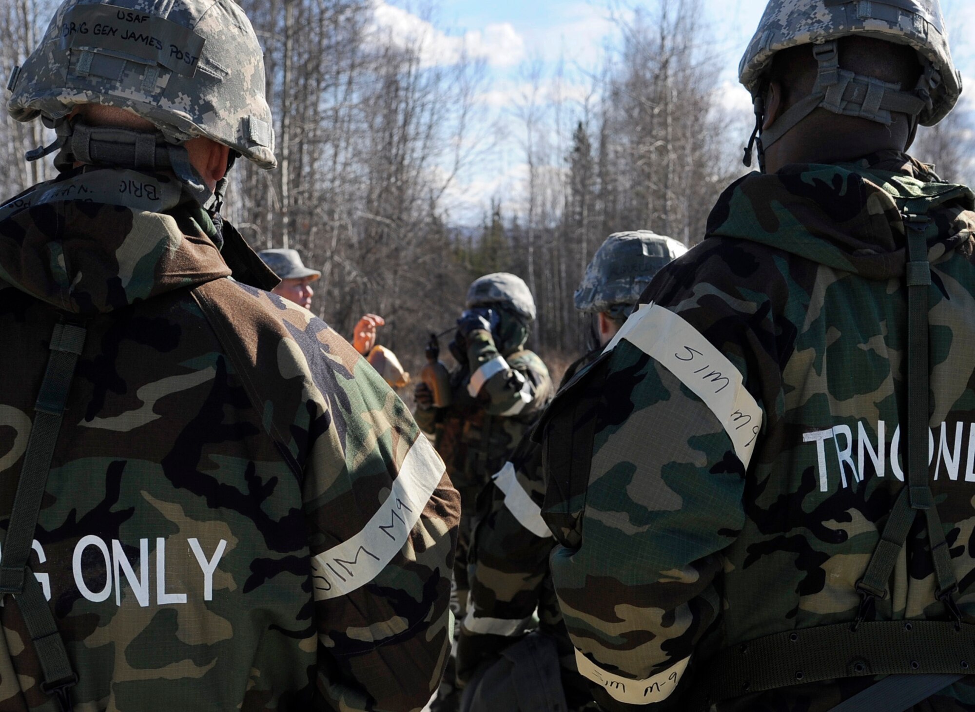Brig.  Gen. James N. Post III and Chief Master Sgt. Jerry Moore observe Airmen drinking water from canteens while in MOPP gear during an operational readiness exercise evaluation May 5, 2011, Eielson Air Force Base, Alaska. The evaluation tests Airmen's ability to survive and operate in a simulated chemical, biological, radiological, nuclear, and high yield explosive environment.  General Post is the 354th Fighter Wing commander and Chief Moore is the 354th FW command chief master sergeant. (U.S. Air Force photo/Airman 1st Class Laura Goodgame) 