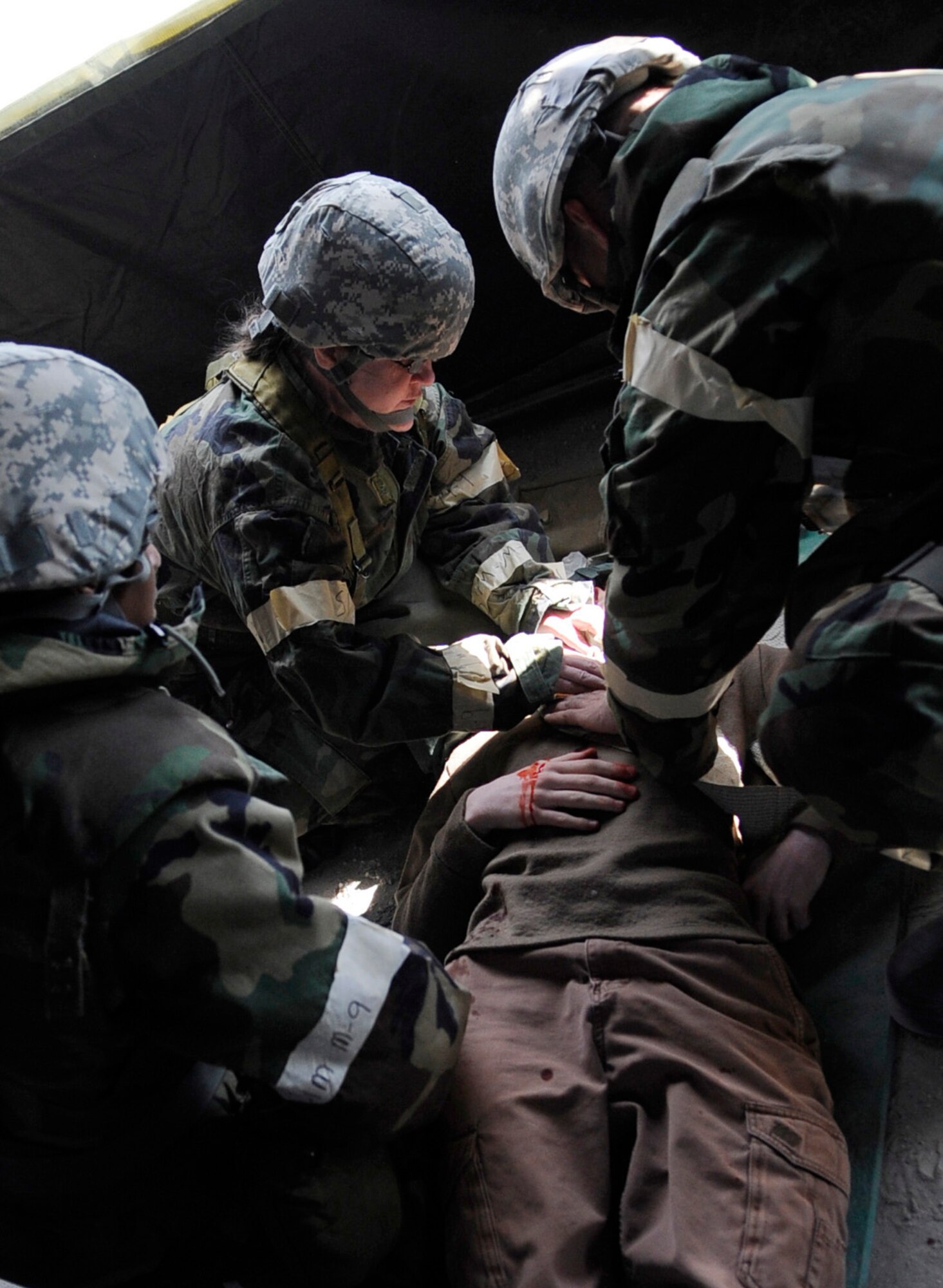 Airmen provide self aid buddy care to an Airman posed as an injured player during an operational readiness exercise evaluation May 5, 2011, Eielson Air Force Base, Alaska. The evaluation tests Airmen's ability to survive and operate in a simulated chemical, biological, radiological, nuclear, and high yield explosive environment.  (U.S. Air Force photo/Airman 1st Class Laura Goodgame) 