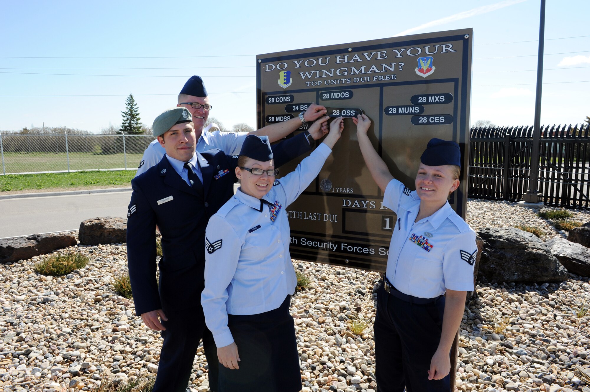 Airmen form the 28th Operation Support Squadron place the 28 OSS patch to the one year DUI- free mark, May 2, 2011, at Ellsworth Air Force Base, S.D., left to right, Airman 1st Class Bryan Wichman, 28th Operations Support Squadron air traffic controller; Senior Airman Zachary Yoakman, 28th OSS survival, evasion, resistance and escape journeyman; Senior Airman Pamela Torres, 28th OSS knowledge operations manager and Senior Airman Stephanie Skelton, 28th OSS aircrew flight equipment journeyman. Each Airmen contributed to the success of the 28th OSS by assisting in 385-RIDE, as well being designated drivers for fellow Airmen. (U.S. Air Force photo/Senior Airman Adam Grant)  
