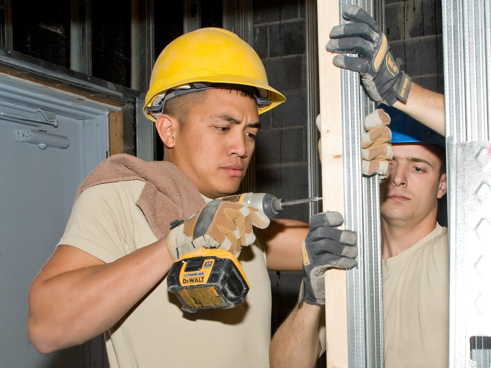 Staff Sgt. Leopoldo Lardizabal (left) and Airman 1st Class Michael Wallace, 436th Civil Engineer Squadron, screw a board into place May 6, 2011, at the Honor Guard facility at Dover Air Force Base, Del. The renovated facility will feature nearly double the floor-space of the original building. (U.S. Air Force photo by Adrian Rowan)