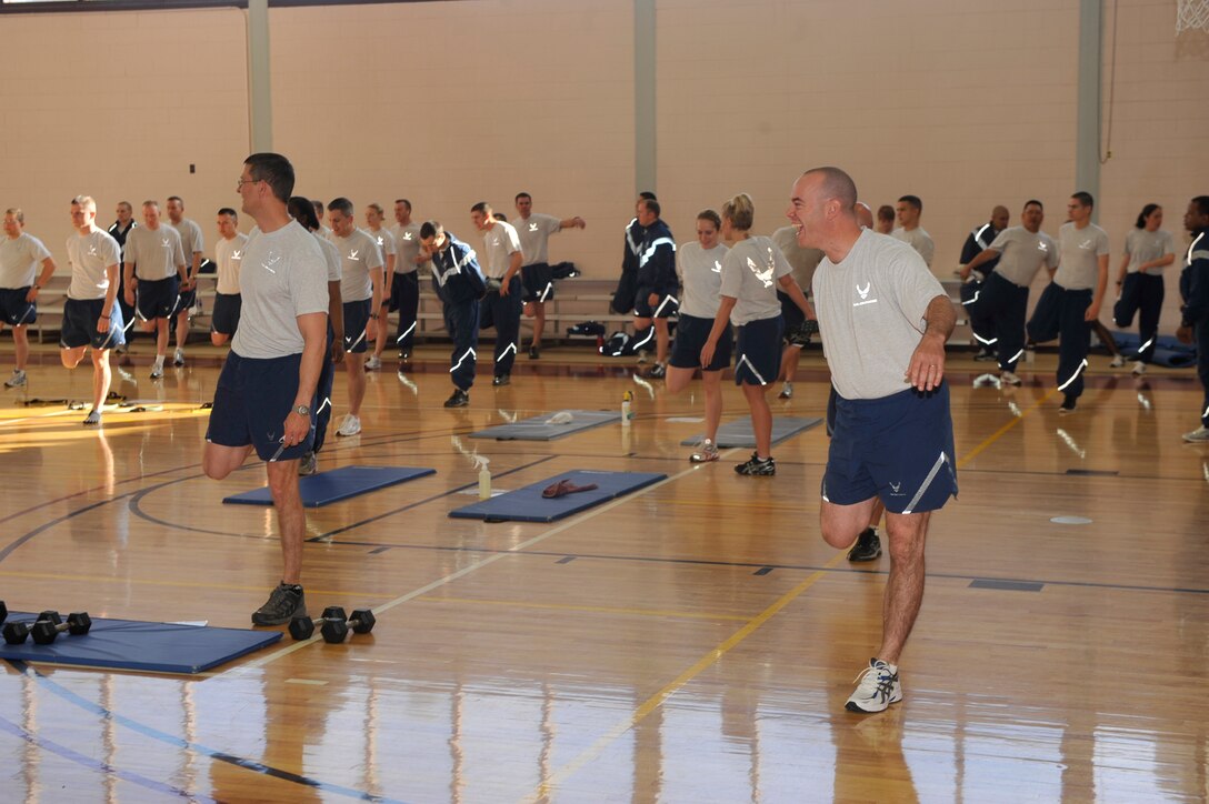 PETERSON AIR FORCE BASE, Colo. – Airmen enjoy the warm-up session bright and early April 28, 2011 for the 21st Space Wing Warfit Day at the Peterson Sports and Fitness Center. About 400 Airmen participated in the event, which included warm-up, interval training, cardio and cool down. Across the Air Force, many squadrons and wings gather one day a month for warfit, to build camaraderie and prepare Airmen to be fit to fight. (U.S. Air Force photo/Robb Lingley)