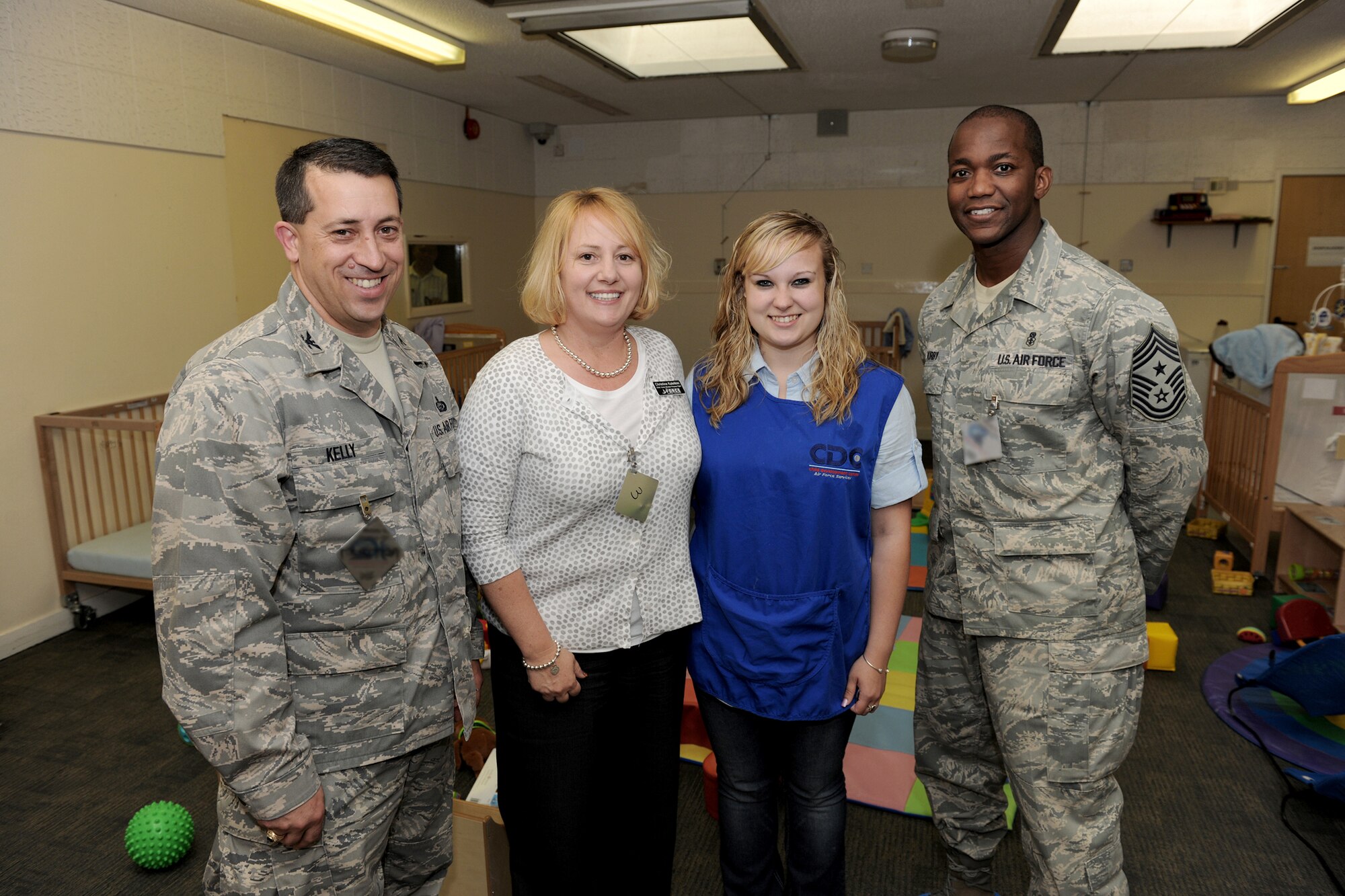 Col. Brian Kelly (far left) and Chief Master Sgt. Larence Kirby (far right) stand with Christine Kaleikini (center left) and Natasha Matthews (center right) in the Royal Air Force Alconbury Child Development Center May 6, 2011, after recognizing the volunteers' efforts to support the Aviano CDC during Operations Odyssey Dawn and Unified Protector. (U.S. Air Force photo/Tech. Sgt. John Barton)