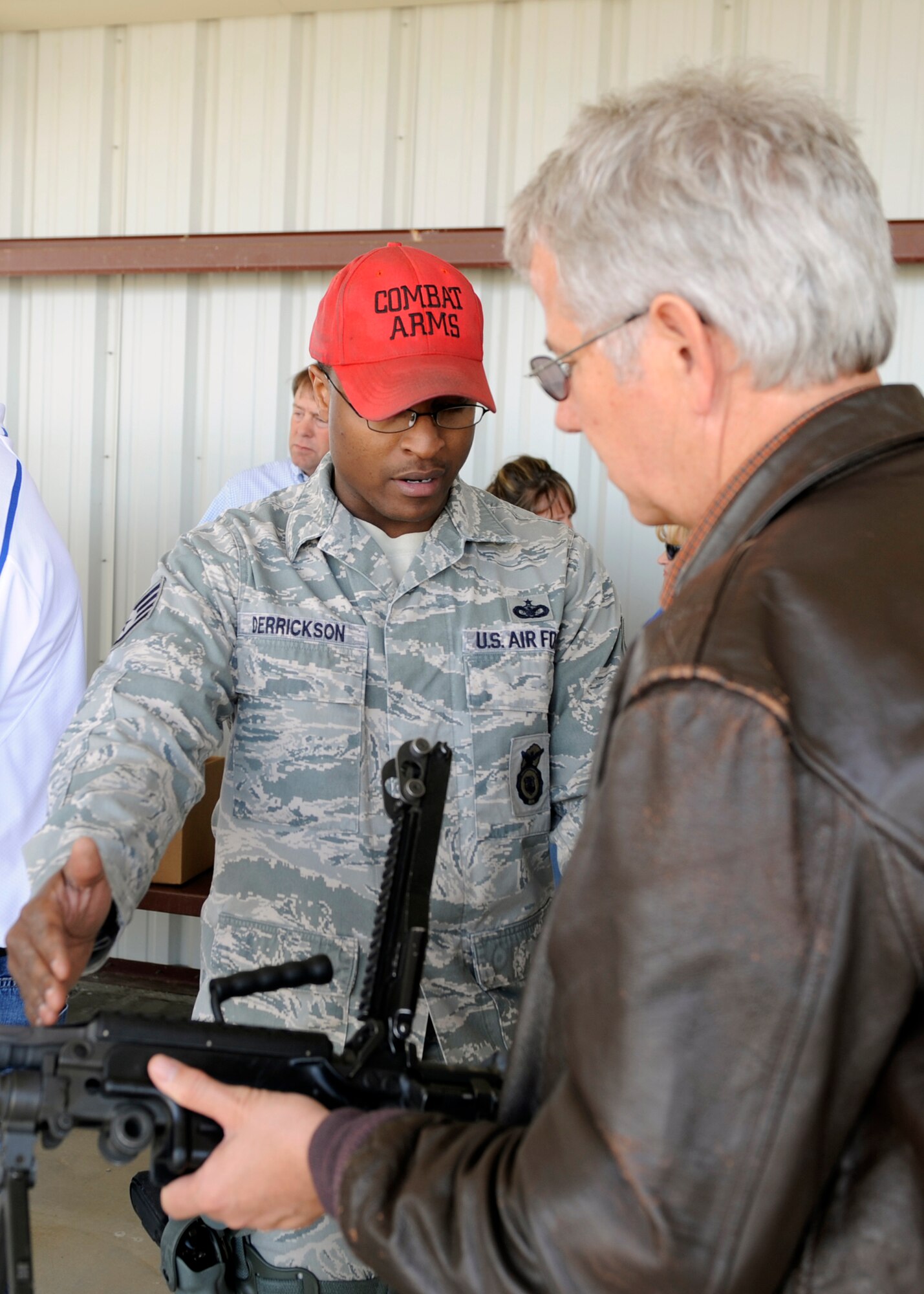 MOUNTAIN HOME AIR FORCE BASE, Idaho – Staff Sgt James Derrickson, 366th Security Forces Squadron, demonstrates to one of the many Military Affairs Committee members the use and function of weapons used by Airmen. The MAC members were permitted to pick up and hold the weapons, feel their weight and inspect the ammunition that would be used by each weapon. (U.S. Air Force photo by Angelina Drake)