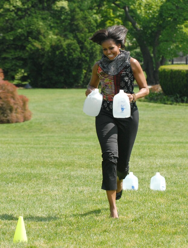 First Lady Michelle Obama navigates an obstacle course with jugs of water during a fitness and nutrition event at the White House, May 9, 2011. 