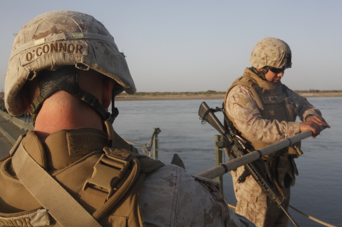 Sgt. John P. O’Connor and Sgt. Ricardo Pereyra-Garcia prepare to check the depth of the Helmand River from an improved ribbon bridge for a daily river report outside of Combat Outpost Payne, Afghanistan, May 11. A half dozen Marine combat engineers from Marine Wing Support Squadron 272, based out of Marine Corps Air Station New River, N.C., teamed up with their U.S. Army counterparts to lend a hand with the bridge’s upkeep. O’Connor and Pereyra-Garcia are both combat engineers with MWSS-272.