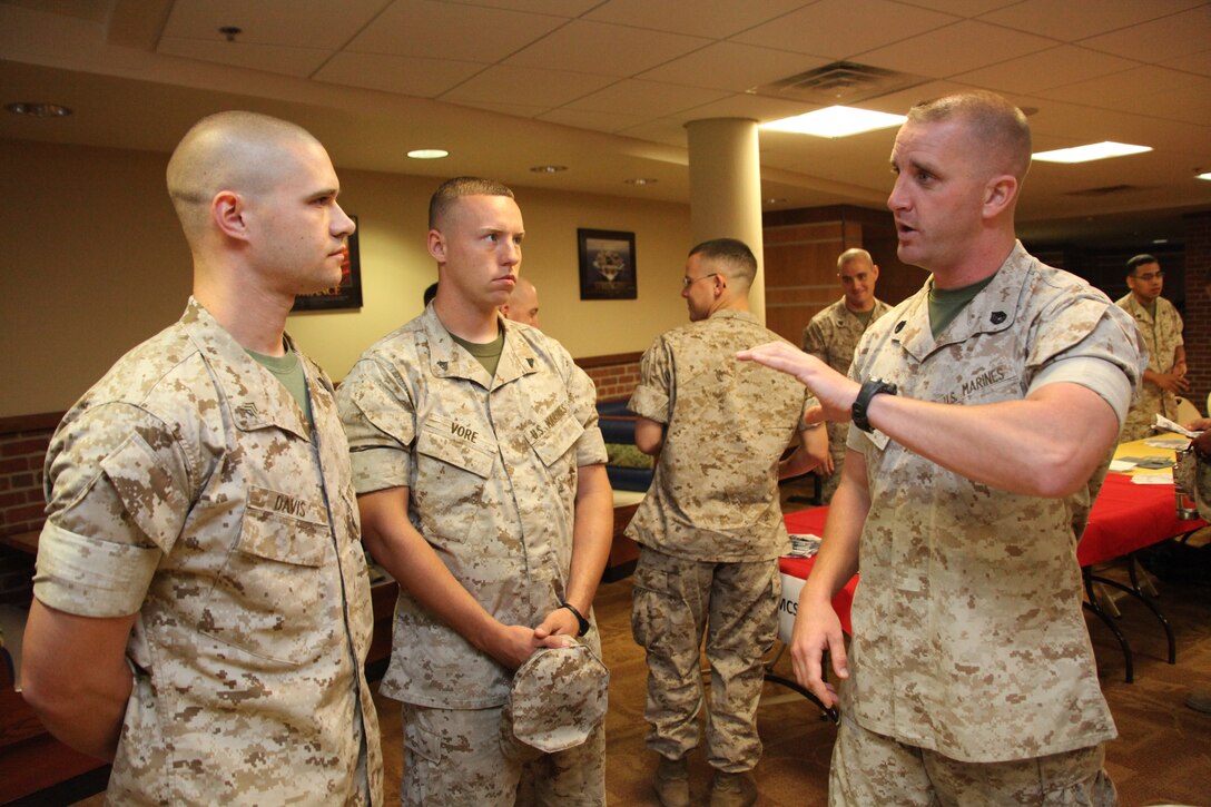 Staff Sgt. Scott R. Beebe, right, a former drill instructor, talks with Sgt. Johnathan B. Davis, left, and Cpl. Cory J. Vore, center, about the possibilities of being a drill instructor after the first-term alignment plan brief at the station theater May 11.