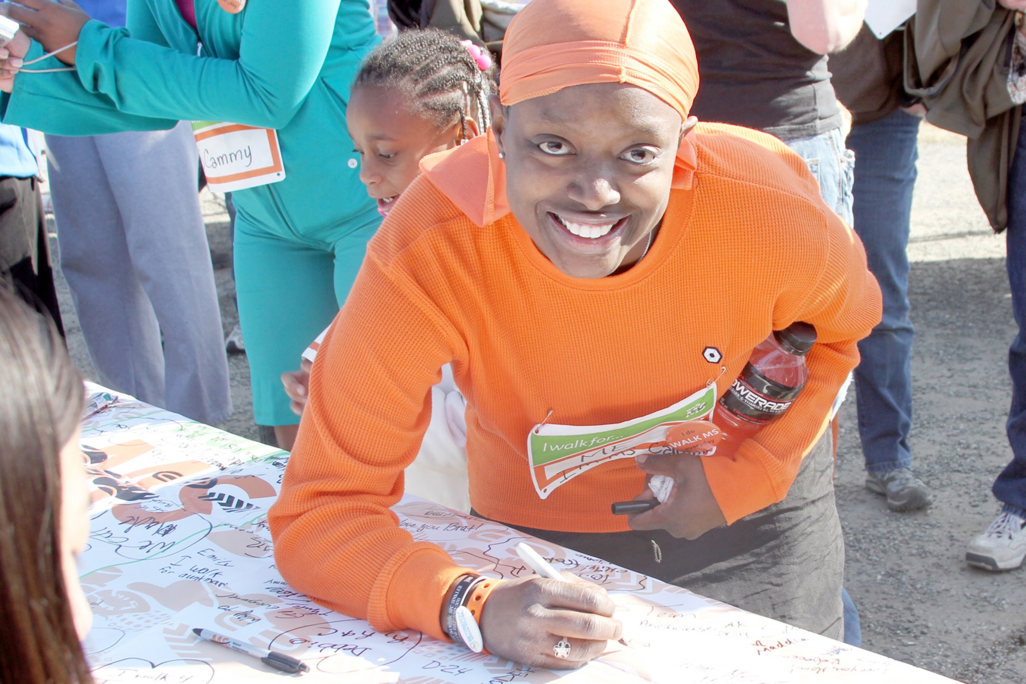 Sgt. Camilia Hall signs her name on the multiple sclerosis banner after completing a four-mile walk in support of finding a cure for multiple sclerosis April 16 in Anchorage. Hall was diagnosed with multiple sclerosis in April 2010. (U.S. Air Force photo\Sgt. Tamika Dillard)