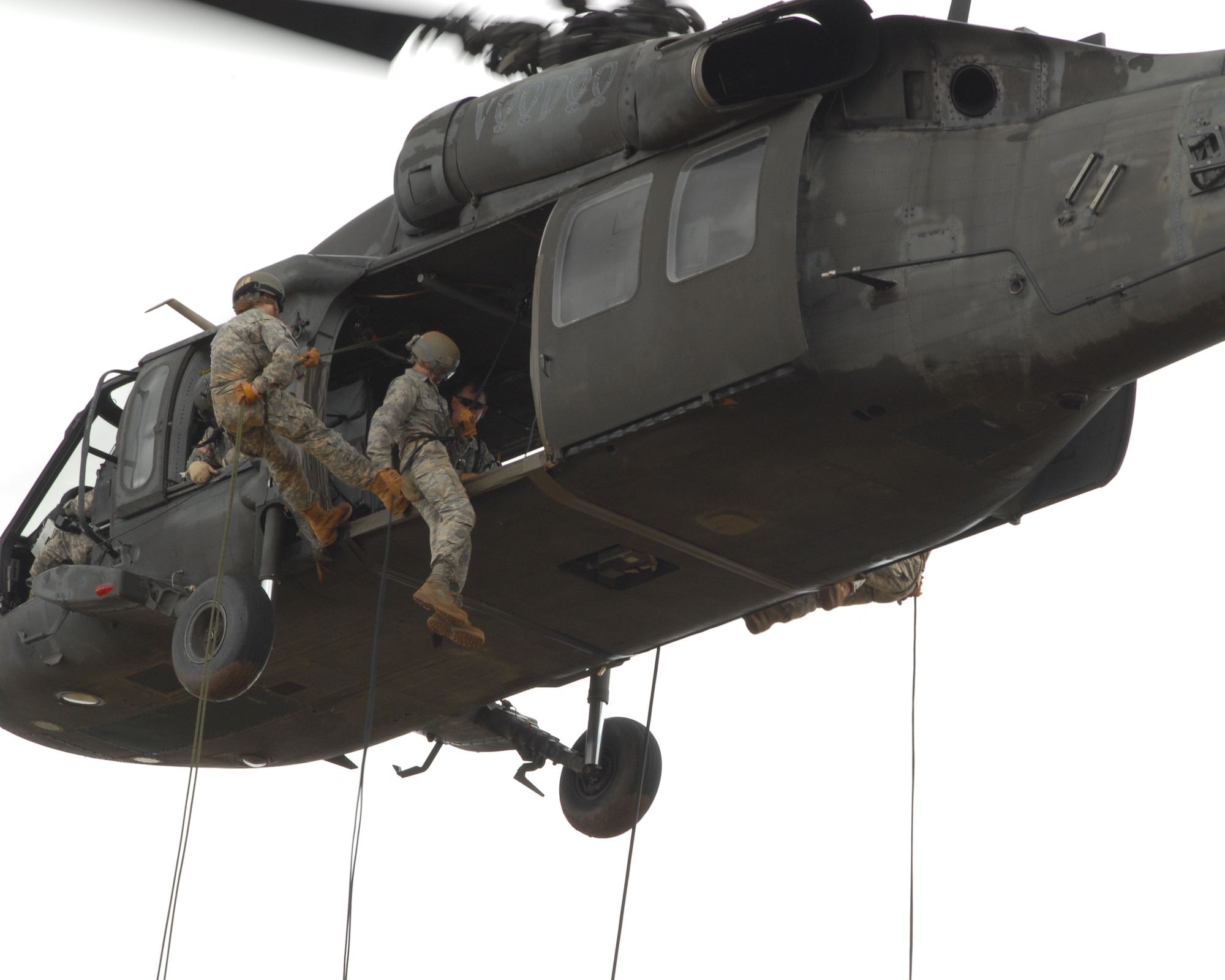 Senior Airman Jordan Miller rappels out of a UH-60 Blackhawk May 10, 2011, in Wahiawa, Hawaii. He and four other 647th Security Forces Squadron Airmen were chosen to participate with 309 Soldiers in an 11-day Army Air Assault course April 30 to May 11, 2011. (U.S. Air Force photo/Staff Sgt. Carolyn Herrick) 
