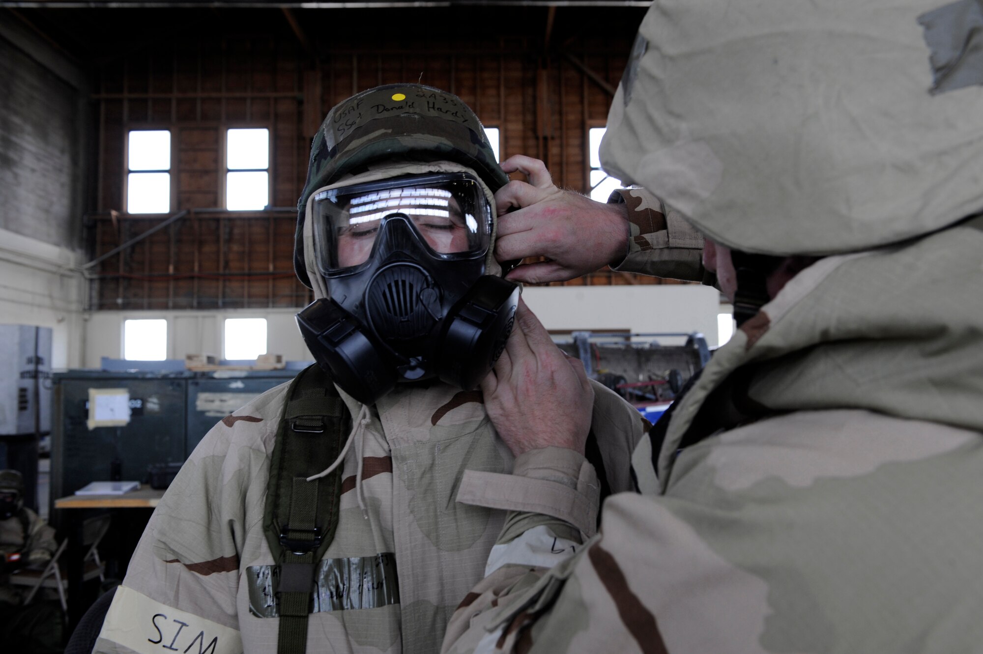MOUNTAIN HOME AIR FORCE BASE, Idaho – Staff Sergeant Donald Hardy, 366th Equipment Maintenance Squadron, has his helmet adjusted by a member of the Exercise Evaluation Team in order to test the fit in his gas mask May 10. Airmen participating in the Phase II Operational Readiness Exercise are required to wear their Mission Oriented Protective Posture gear. (U.S. Air Force photo by Senior Airman Angelina Drake)
