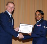 Senior Airman Kanita Pruitt, 71st Force Support Squadron, accepts her Community College of the Air Force diploma from Col. Russ Mack, the 71st Flying Training Wing commander, during a wing commencement ceremony May 5 at the Base Auditorium. Airman Pruitt received the $400 Airman 1st Class William Pitsenbarger scholarship and is seeking a bachelor in criminal justice. (U.S. Air Force photo/ Terry Wasson)