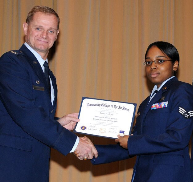 Senior Airman Kanita Pruitt, 71st Force Support Squadron, accepts her Community College of the Air Force diploma from Col. Russ Mack, the 71st Flying Training Wing commander, during a wing commencement ceremony May 5 at the Base Auditorium. Airman Pruitt received the $400 Airman 1st Class William Pitsenbarger scholarship and is seeking a bachelor in criminal justice. (U.S. Air Force photo/ Terry Wasson)