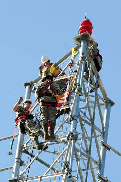 Capt. Keith Lorenz administers the Oath of Enlistment to Senior Airman John Hines, both from 2nd Communications Squadron, on a communications tower on Barksdale Air Force Base, La., May 6. Airman Hines is the first Barksdale cable maintainer to have the opportunity to be reenlisted at 149 feet. (U.S. Air Force photo/Senior Airman Joanna M. Kresge)