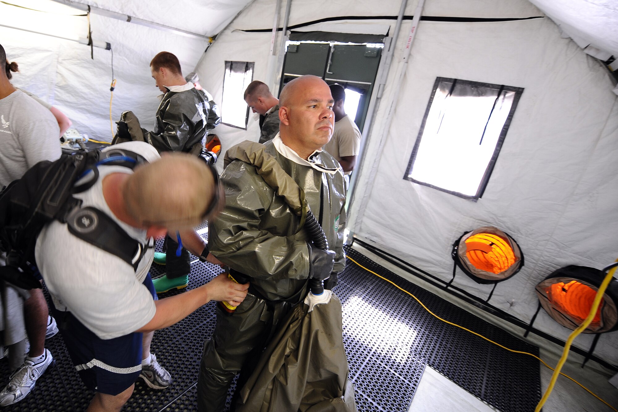 OFFUTT AIR FORCE BASE, Neb. - Tech Sgt. Shawn VanConett removes the Tychem Suit from Tech. Sgt. Anthony Porter following a decontamination exercise held inside of the DECON tent located at the McCoy Hall parking lot, here, May 10. Frequent  training ensures the medical professionals are capable of moving people efficiently through the decontamination tent. U.S. Air Force Photo by Josh Plueger (released)
