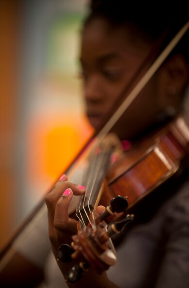 Jovan DeShong, Valdosta State University music education major, shows children at the Child Development Center the different sounds made on the violin by pressing different strings and moving the bow May 9 at Moody Air Force Base, Ga. In speaking on the opportunity, Ms. DeShong said teaching music was her passion and she hoped to make an impact with the children by giving them something to use in the future. (U.S. Air Force photo/ Airman 1st Class Joshua Green)(RELEASED)
