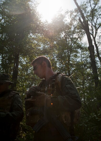 Master Sgt. Randy VanHorn, 41st Rescue Squadron flight engineer, uses only a compass to navigate through a forest during evasion training with his fellow team members May 10 at Moody Air Force Base, Ga. This portion of the training required them to navigate and evade until they linked up with pararescuemen for evacuation. (U.S. Air Force photo/Airman 1st Class Nicholas Benroth)(RELEASED)
