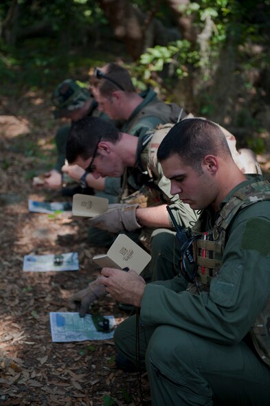 Members of the 347th Rescue Group plot required navigation points on their maps during survival, evasion, resistance and escape refresher training May 10 at Moody Air Force Base, Ga. The participants used compasses and maps to find their location points and later navigated from that location to the next using only their compass. (U.S. Air Force photo/Airman 1st Class Nicholas Benroth)(RELEASED)
