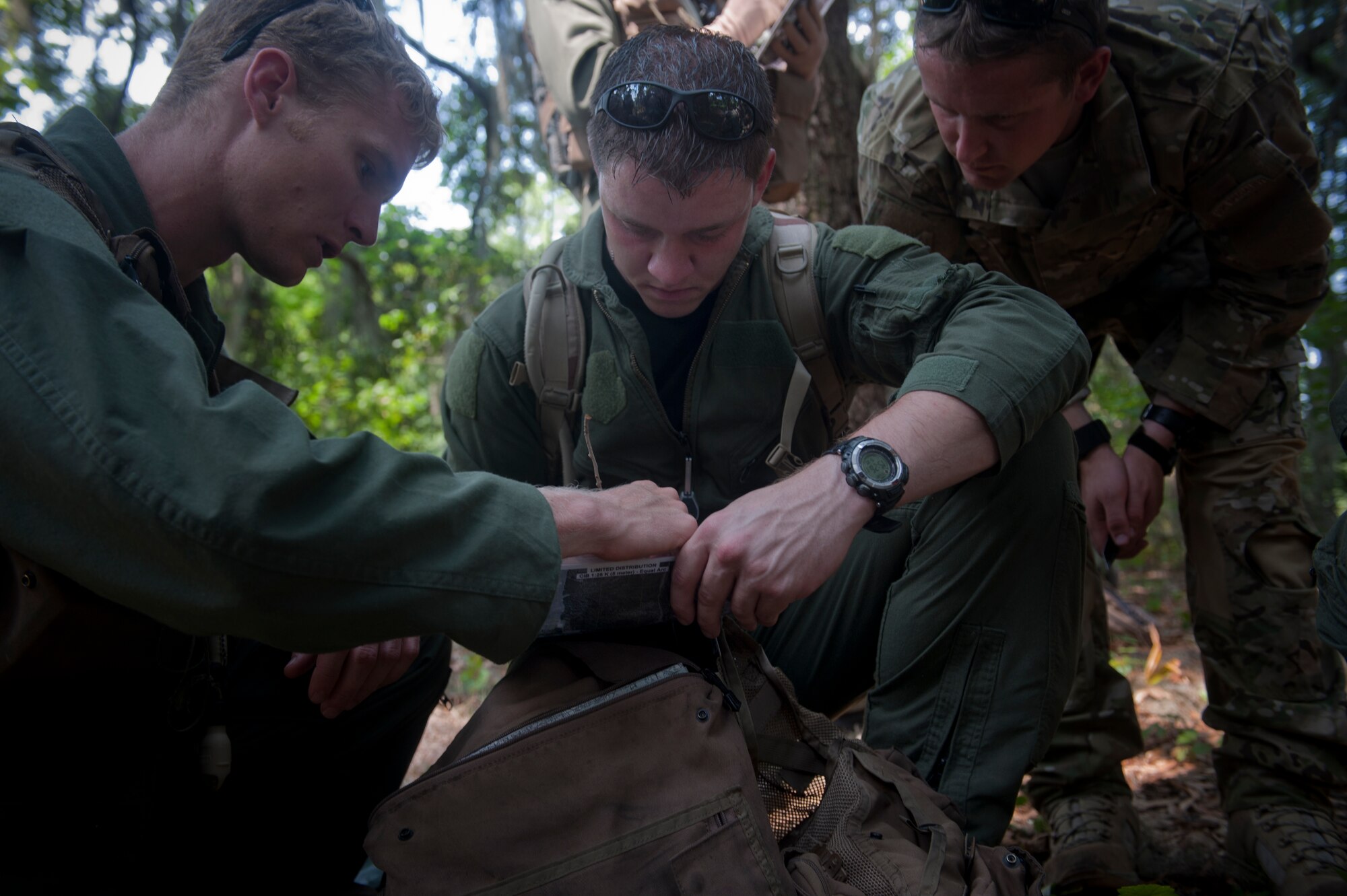 Members of the 347th Rescue Group use a map and compass to help navigate to their destination at Moody Air Force Base, Ga., May 10. The map was used to help identify their general location while moving on foot through the dense forest. (U.S. Air Force photo/Airman 1st Class Douglas Ellis)(RELEASED)
