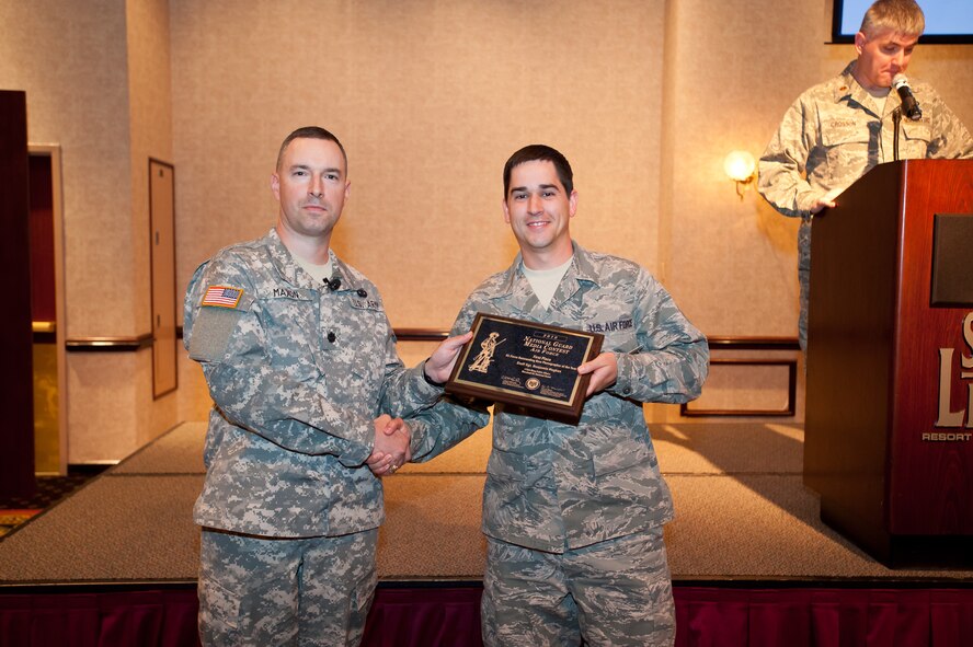 (L-R) Lt. Col. Eric Maxon, National Guard Bureau Acting Director, Public Affairs and Strategic Communications, presented a plaque to Staff Sgt. Benjamin Hughes, who won first place in the 2010 Air Force Media Contest as outstanding new photographer of the year on May 5, 2011 in Reno, NV.  
Sgt. Hughes is a 175th Wing Public Affairs Still Photo Specialist from Warfield Air National Guard Base, Baltimore, Md.
(U.S. Air Force photo/Master Sgt. John Nimmo, Sr.) (RELEASED)
