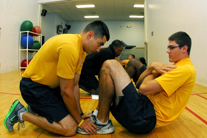 Information Systems Technician Seaman Brian Latour conducts the sit-up portion of his Physical Fitness Assessment as his partner, Machinist’s Mate 3rd Class Michael Barbaro, holds his feet and keep count during the bi-annual physical readiness test for Naval Support Activity personnel at Sam’s Gym on Joint Base Charleston-Weapons Station.  The PFA, conducted every six months, consists of a cardiovascular test, push-ups and sit-ups examining each Sailor’s cardio-respiratory endurance, muscular strength and stamina performance. (U.S. Navy photo/Machinist’s Mate 3rd Class Brannon Deugan)
