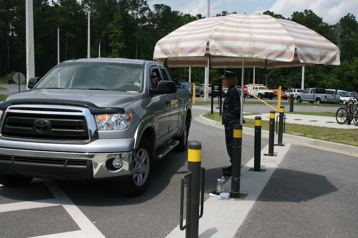 A pharmacy technician assigned to the Naval Health Clinic Charleston on Joint Base Charleston - Weapons Station, assists a customer with his prescription. Due to an upgrade in security, the pharmacy drive-thru is temporarily closed. Patrons can use this modified drive-thru system and still expect timely and professional service. (U.S. Navy photo/Jeff Kelly)