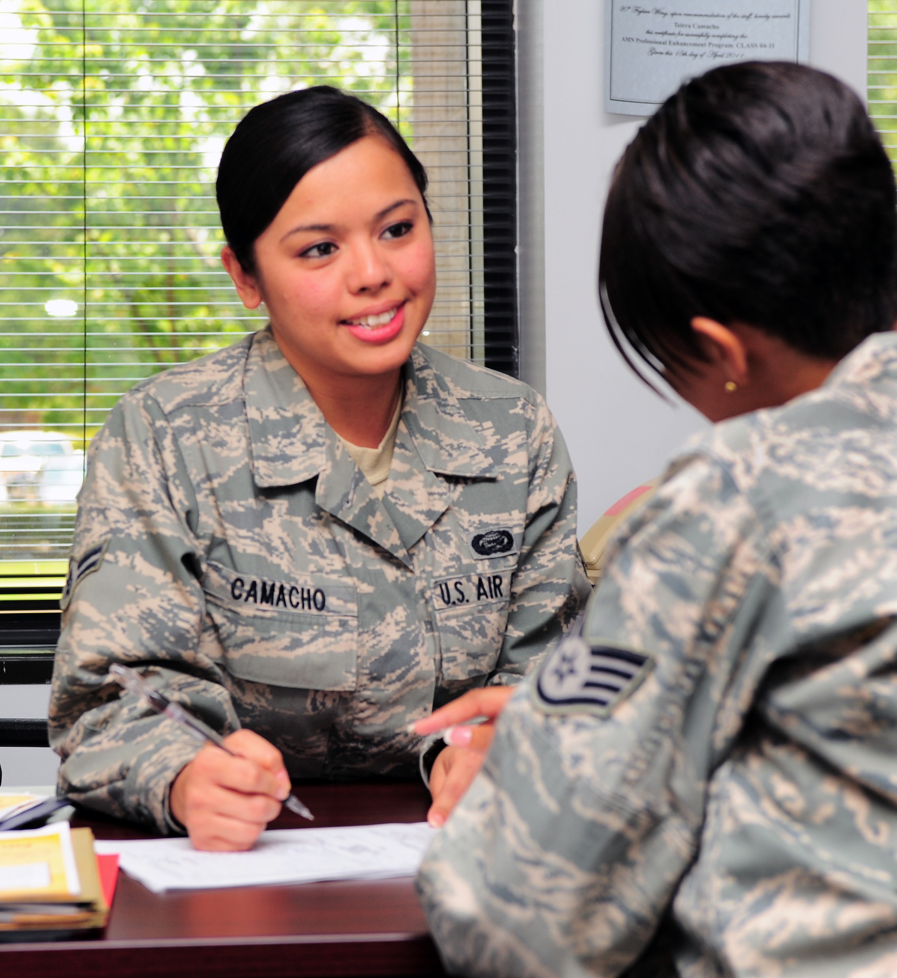SHAW AIR FORCE BASE, S.C. -- Airman 1st Class Teirra Camacho, 20th Force Support Squadron force management, speaks with Staff Sgt. Chiquita Young, 20th FSS force management, here May 11, 2011. Airman Camacho is the Warrior of the Week for the week of May 9-13. (U.S. Air Force photo/Airman 1st Class Daniel Phelps (Released))
