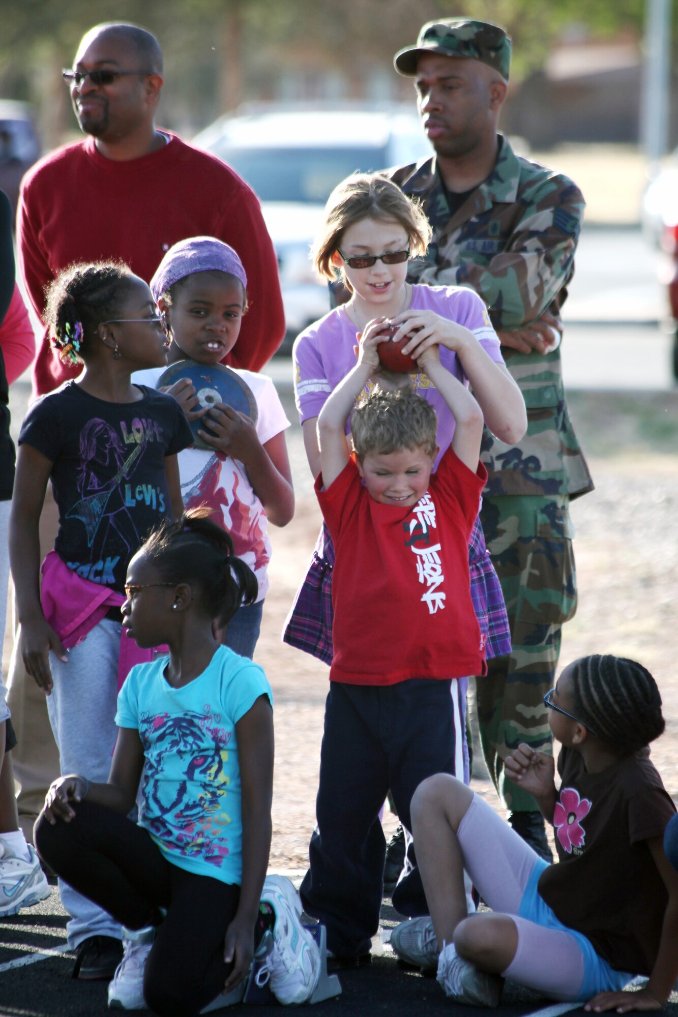 During the Youth Center's track and field clinic, children pass around, and test the weight of the shot put and discus, at the Cannon Air Force Base, N.M. track May 5, 2011.  During this two-day clinic children and their parents were able to learn more about the different aspects of competing in track sports. (U.S. Air Force photo by Airman 1st Class Jette Carr)(RELEASED)
