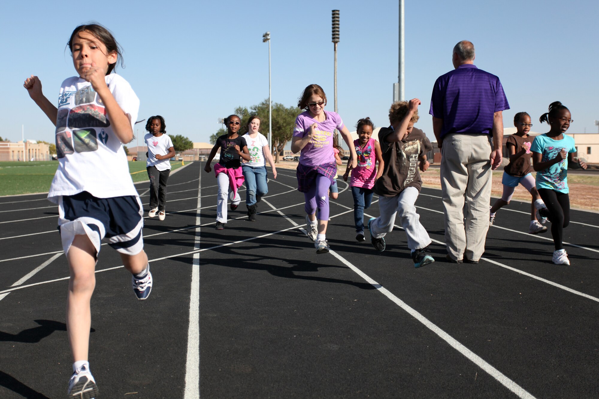 Children sprint to the finish line during a track and field clinic held at Cannon Air Force Base, N.M. May 5, 2011. Specialists came to teach children, primarily from the Youth Center, the mechanics of running and other track sports such as shot-put and relay races. (U.S. Air Force photo by Airman 1st Class Jette Carr)(RELEASED)