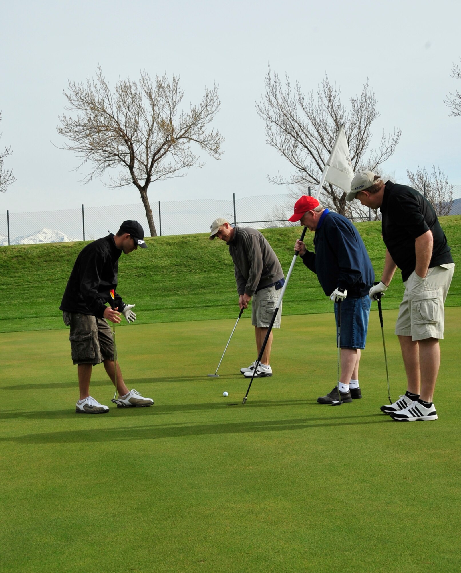 Senior Master Sgt. Matt McElreath watches his golf ball creep toward the hole as teammates Senior Master Sgt. Noah Rosales, retired Chief Master Sgt. David Sill and Mr. Matt McIntosh look on. The 419th Fighter Wing’s Top 3 organization hosted a golf tournament May 6, raising more than $500 for wing events and enlisted personnel. (U.S. Air Force photo/Kim Cook)