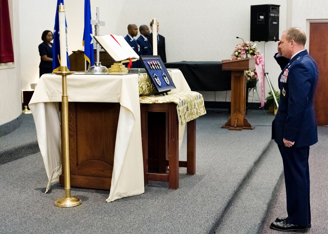 Brig. Gen. Kevin Jacobsen, AFOSI commander, renders a salute to MSgt. Tara Brown's rank and medals during a memorial service held May 9 in her honor at Joint Base Andrews, Md.. Sergeant Brown was one of nine Americans killed during a shooting April 27 at Kabul International Airport, Afghanistan. (U.S. Air Force Photo by Mike Hastings.)