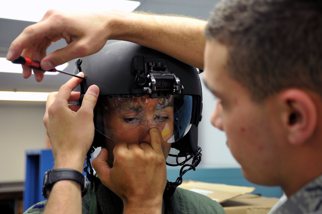Airman 1st Class Daniel Sotelo, 811th Operation Support Squadron aircrew flight equipment technician, custom fits the visor assembly to 1st Lt. Vince Giacomino, 1st Helicopter Squadron, pilot May 10. The visor must be adjusted to each aircrew’s face to ensure it properly protects the Airmen’s eyes. (U.S. Air Force photo by Senior Airman Perry Aston) (Released)
